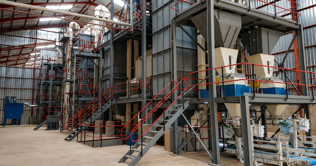 Large industrial processing and material-handling facility with elevated platforms, hoppers, conveyors and transfer systems, representing flow stability, throughput continuity and industrial movement under pressure.